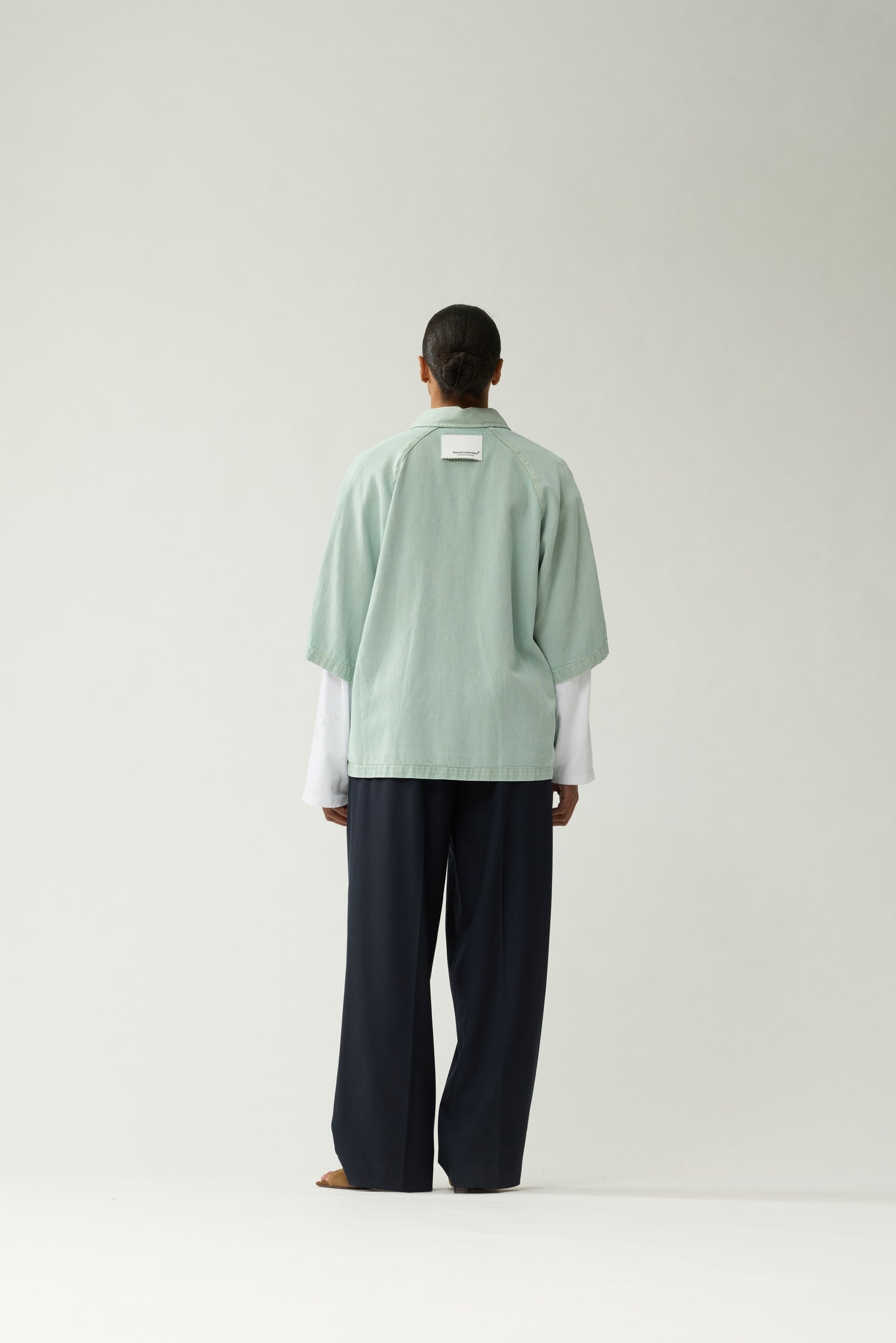 New Amsterdam Surf Association Mint Denim Short Sleeve Button-Up Shirt - Model Back View Dropped Shoulders Hip Length