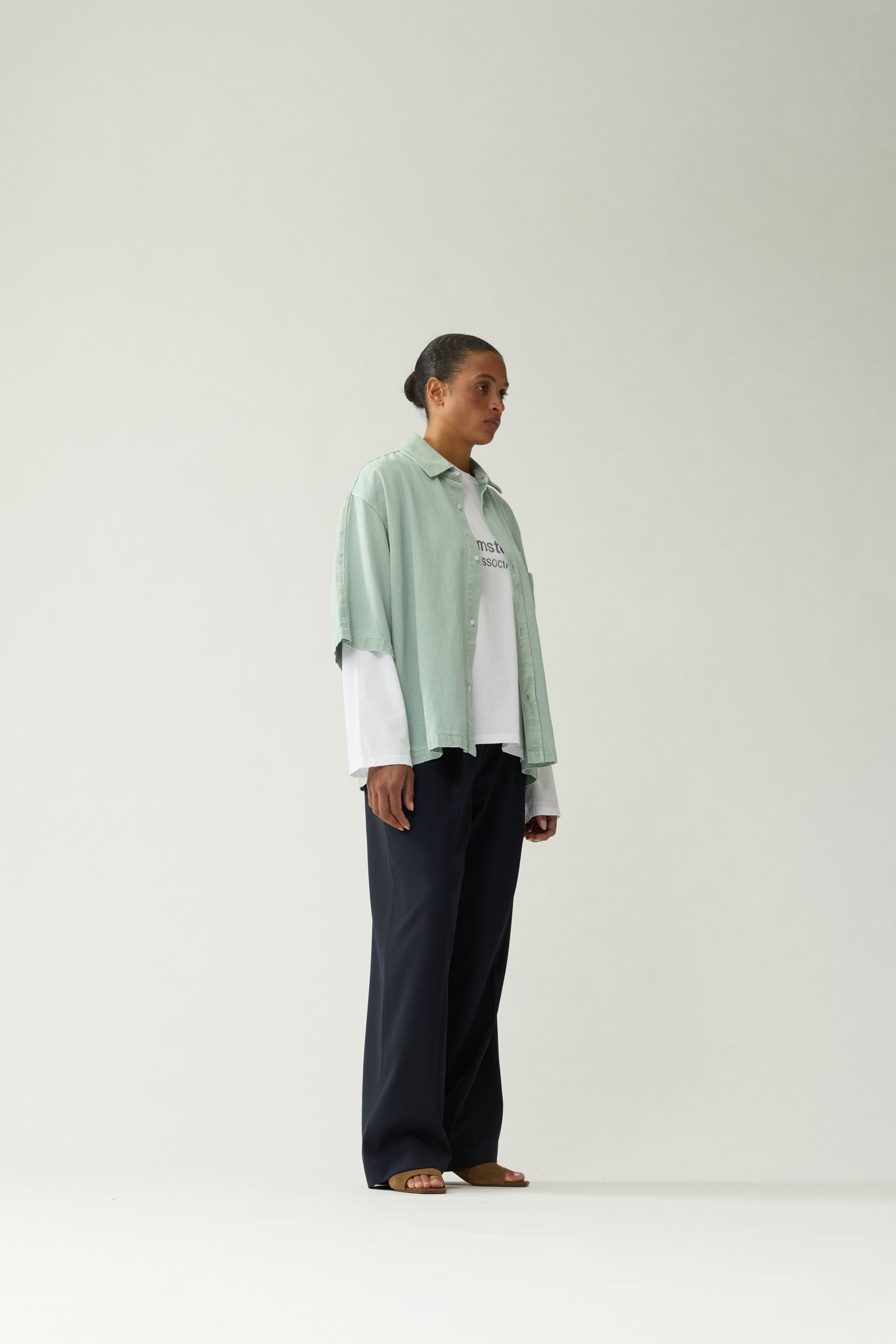 New Amsterdam Surf Association Mint Denim Short Sleeve Button-Up Shirt - Model Three-Quarter Side View Button-Up Chest Pocket