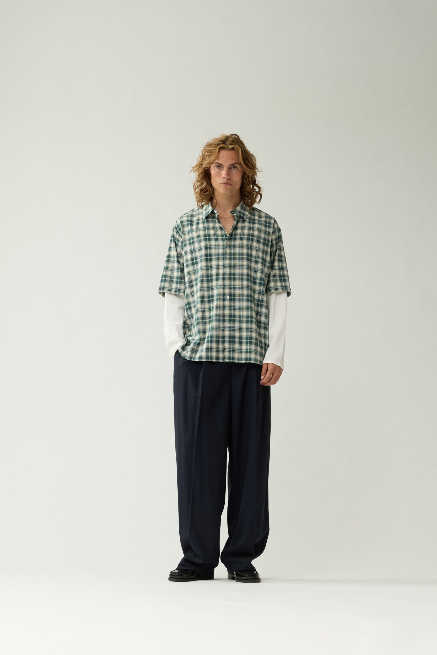 New Amsterdam Surf Association Double Layer Shirt in Green — male model wearing green/white check double layer shirt, front view, relaxed fit with contrast white long sleeves