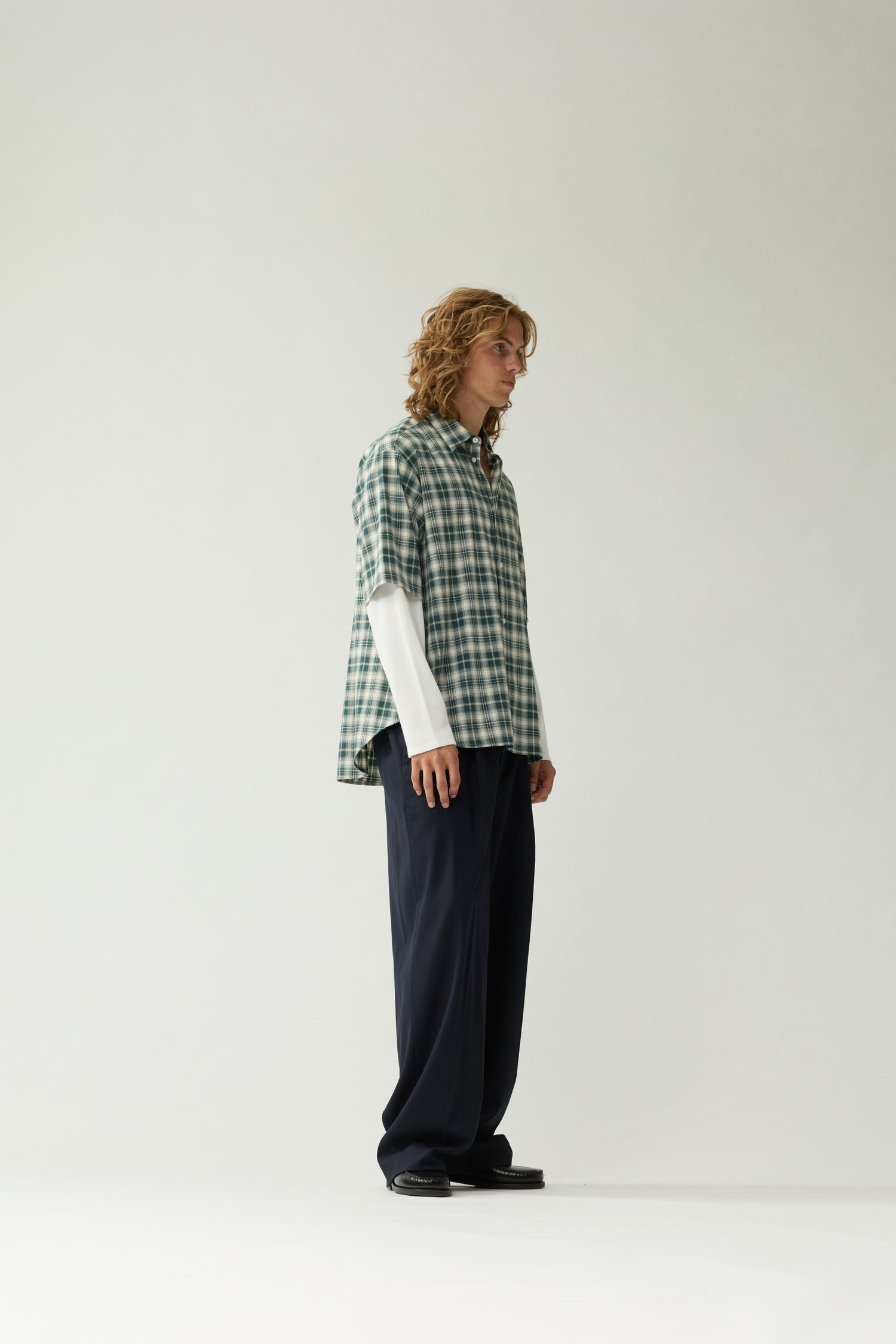 New Amsterdam Surf Association Double Layer Shirt in Green — male model wearing green/white check double layer shirt, side view highlighting relaxed fit and layered sleeve construction