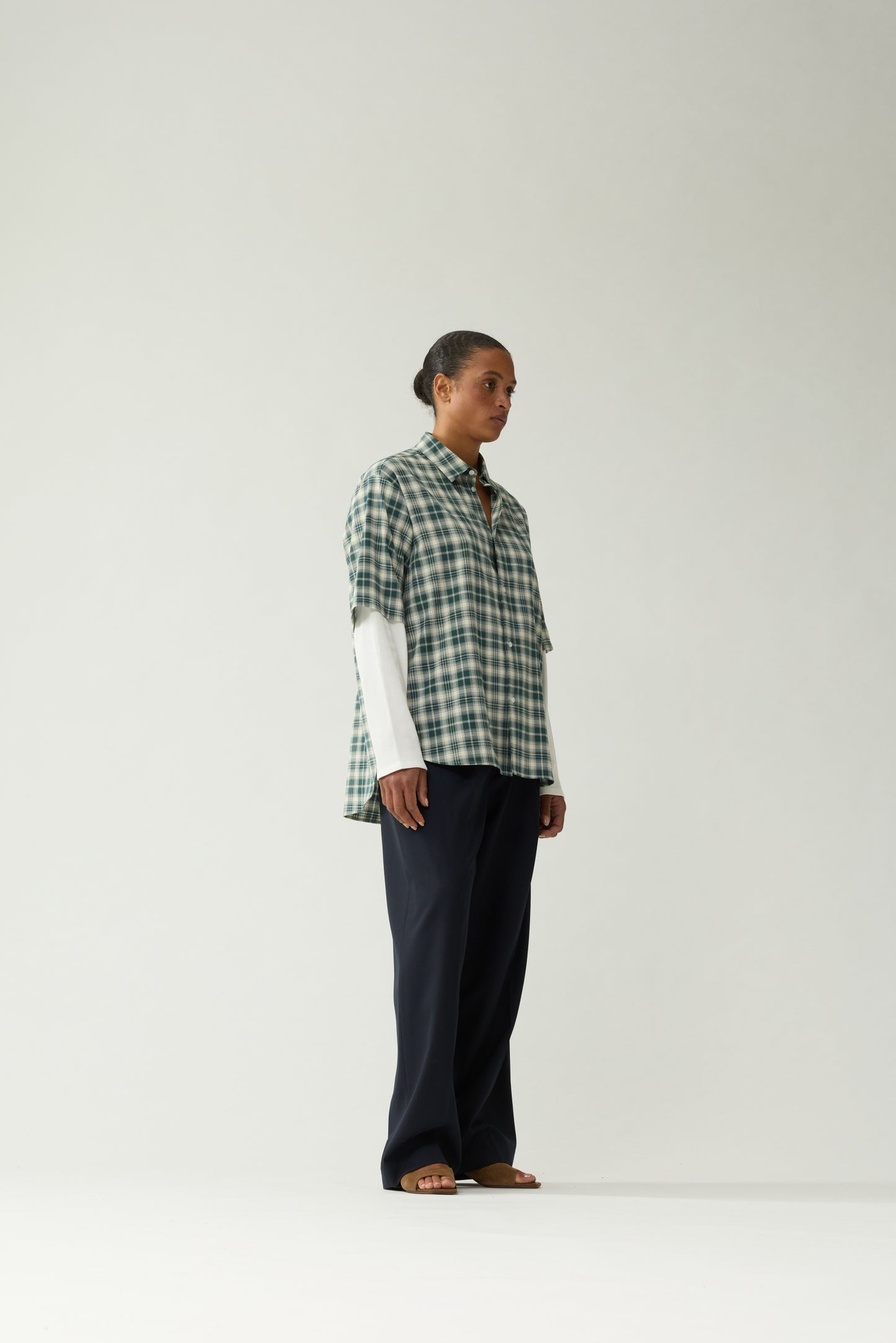 New Amsterdam Surf Association Double Layer Shirt in Green — female model wearing green/white check double layer shirt, side view showing relaxed fit and double layer construction