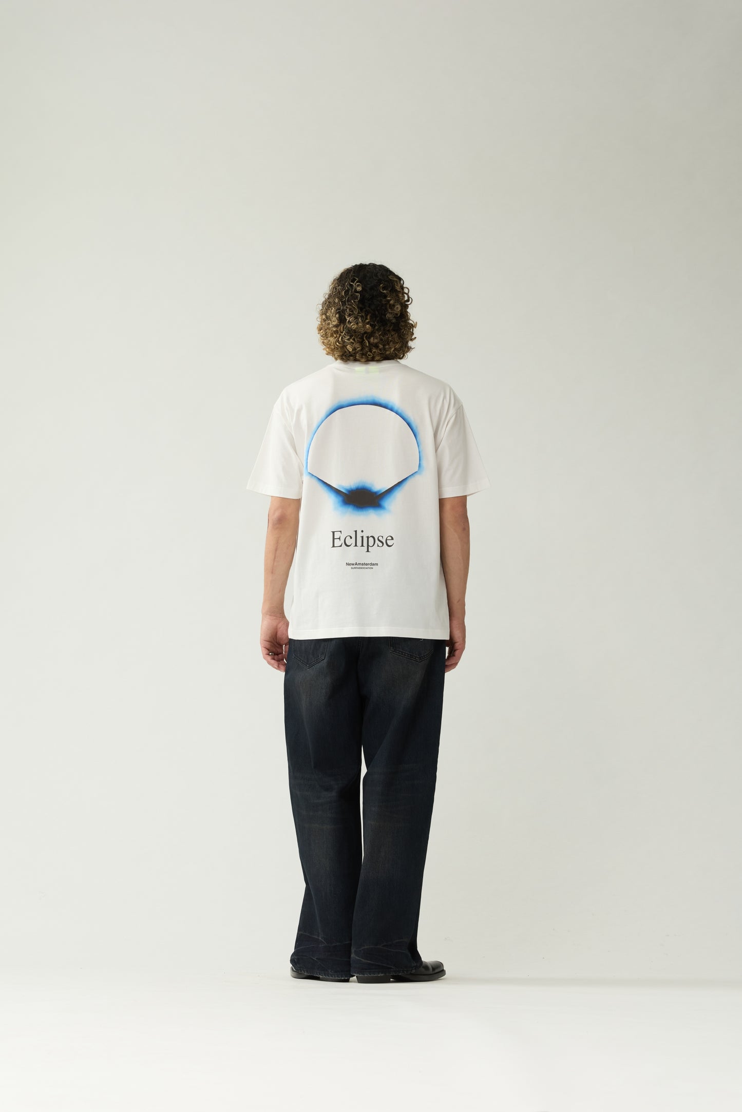 New Amsterdam Surf Association White Eclipse Tee - Model Back View Large Eclipse Ring Graphic Back Print T-Shirt