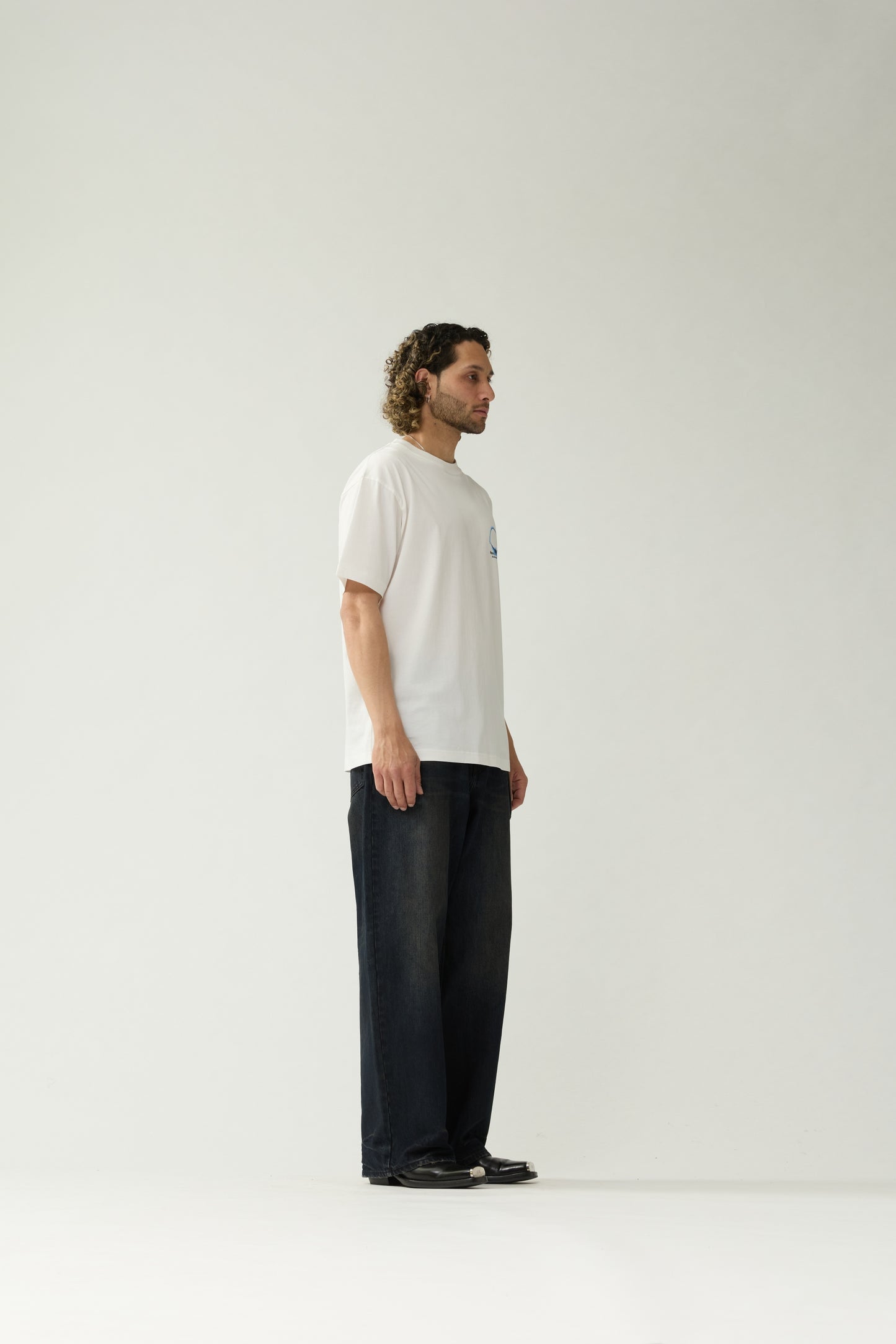 New Amsterdam Surf Association White Eclipse Tee - Model Side Profile View Relaxed Fit Graphic Tee Streetwear