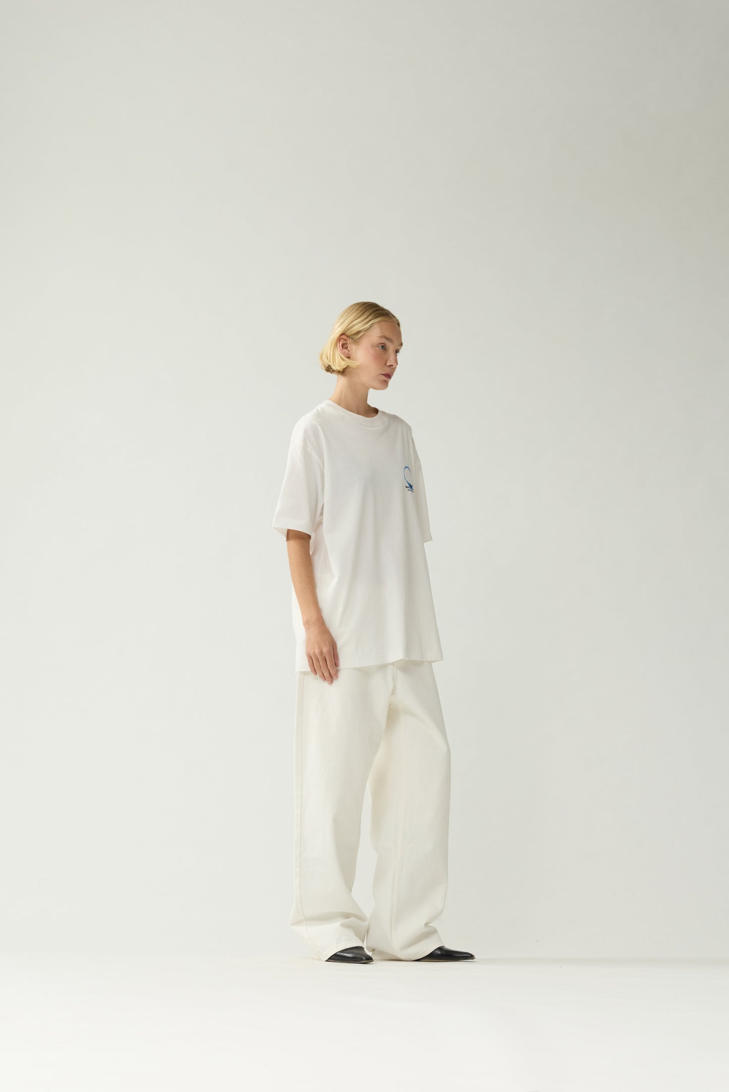 New Amsterdam Surf Association White Eclipse Tee - Model Three-Quarter View Dropped Shoulder Cotton T-Shirt