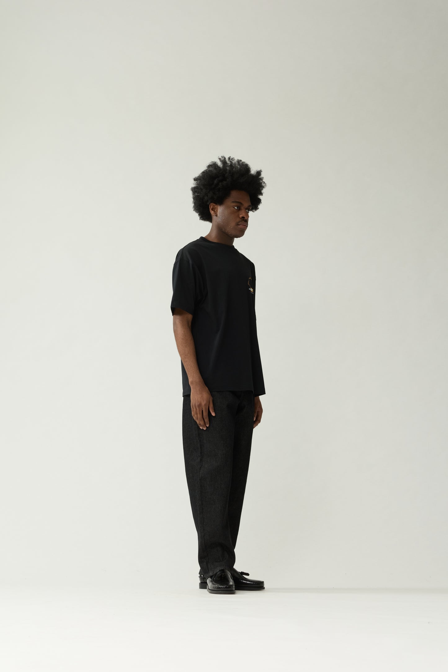 New Amsterdam Surf Association Black Eclipse Tee - Model Front View Full Body Oversized Fit Black Graphic T-Shirt