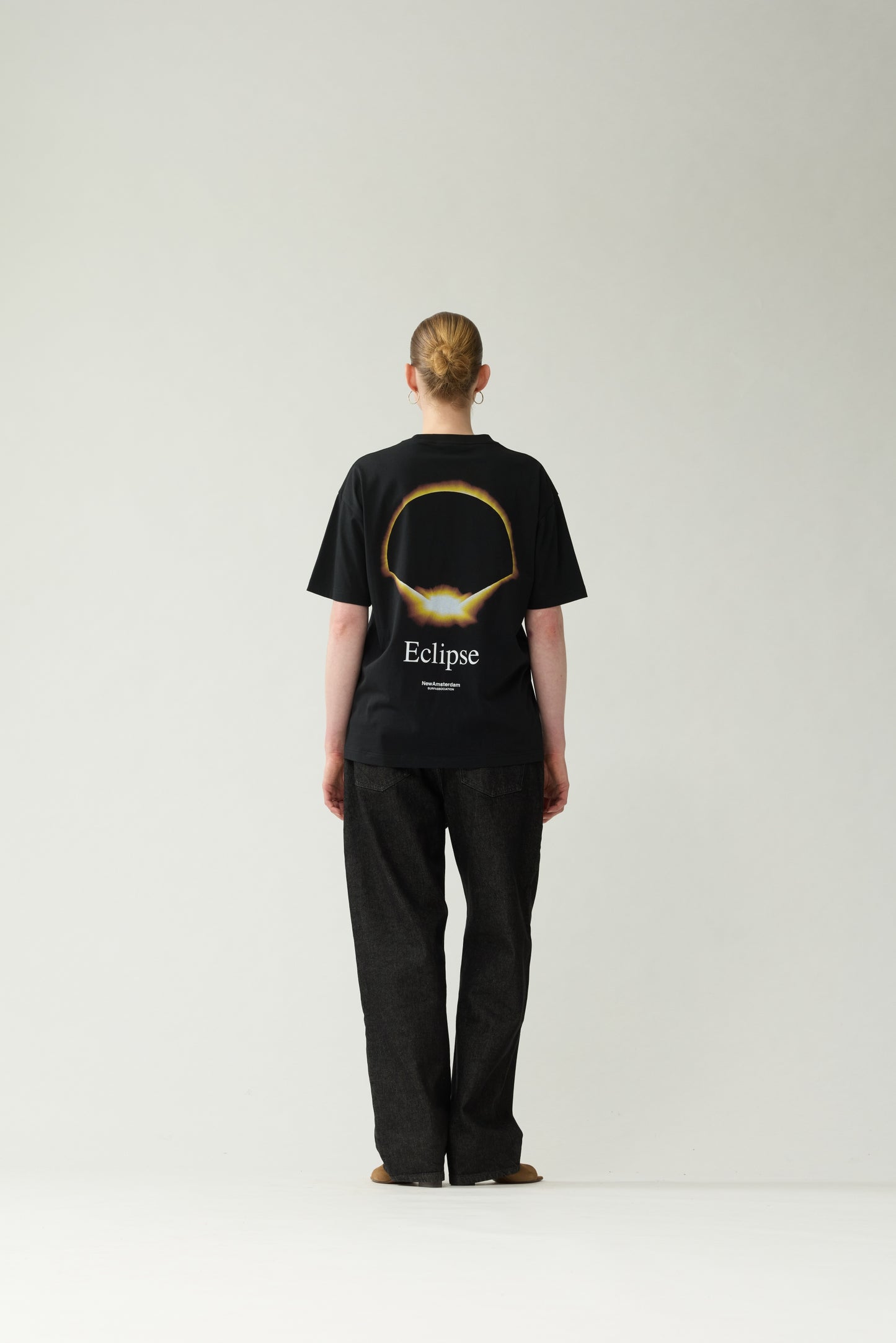 New Amsterdam Surf Association Black Eclipse Tee - Model Back View Golden Eclipse Back Print Dropped Shoulder Tee
