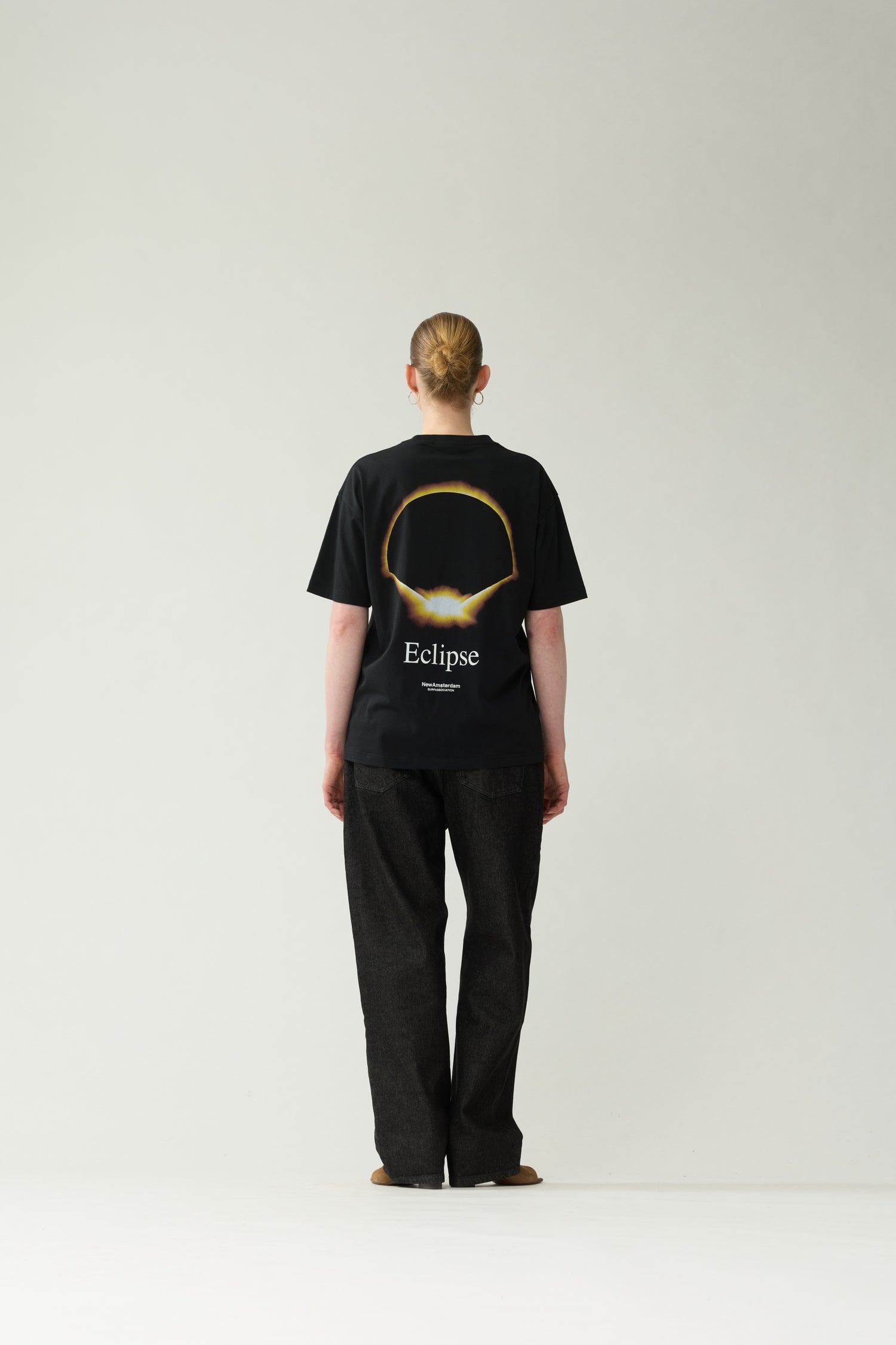 New Amsterdam Surf Association Black Eclipse Tee - Model Back View Golden Eclipse Back Print Dropped Shoulder Tee