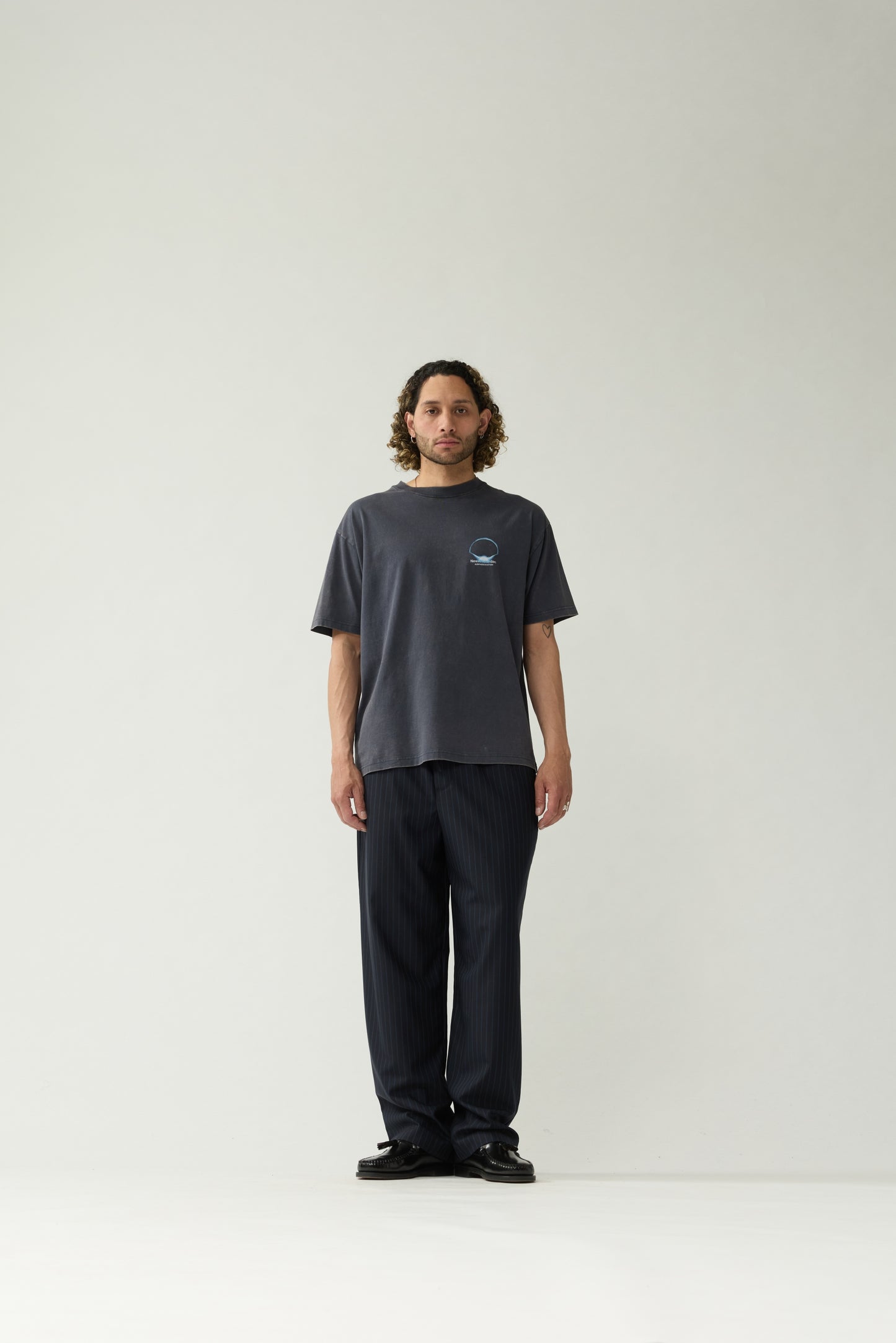 New Amsterdam Surf Association Eclipse Tee in Night — model wearing dark navy unisex crewneck tee, front view, regular fit