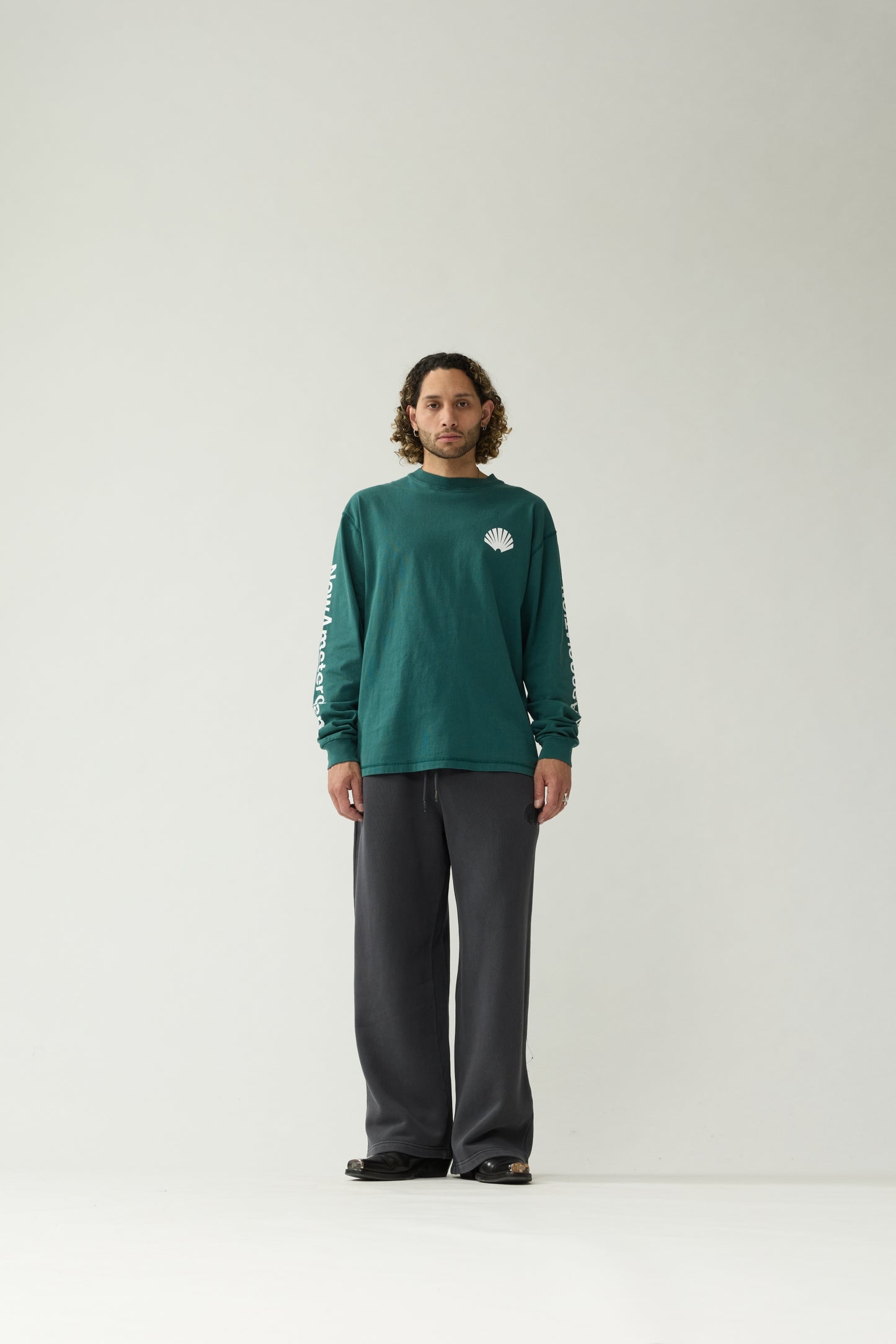 New Amsterdam Surf Association Logo Longsleeve in Bottle Green — male model wearing bottle green crewneck longsleeve, front view, regular unisex fit with chest shell logo and sleeve screenprint